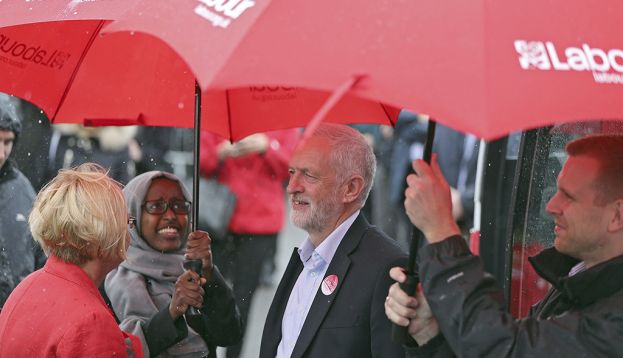 HEMLINGTON (REINO UNIDO) 05/06/2017.- El líder de la oposición laborista, Jeremy Corbyn, se protege de la lluvia bajo un paraguas durante un acto de campaña para los comicios generales de este jueves en Hemlington (Reino Unido), hoy, 5 de junio de 2017. Corbyn pidió hoy la dimisión de la primera ministra británica, Theresa May, por los recortes en el número de agentes de Policía, a raíz del debate sobre la seguridad tras del atentado de Londres. EFE/Nigel Roddis